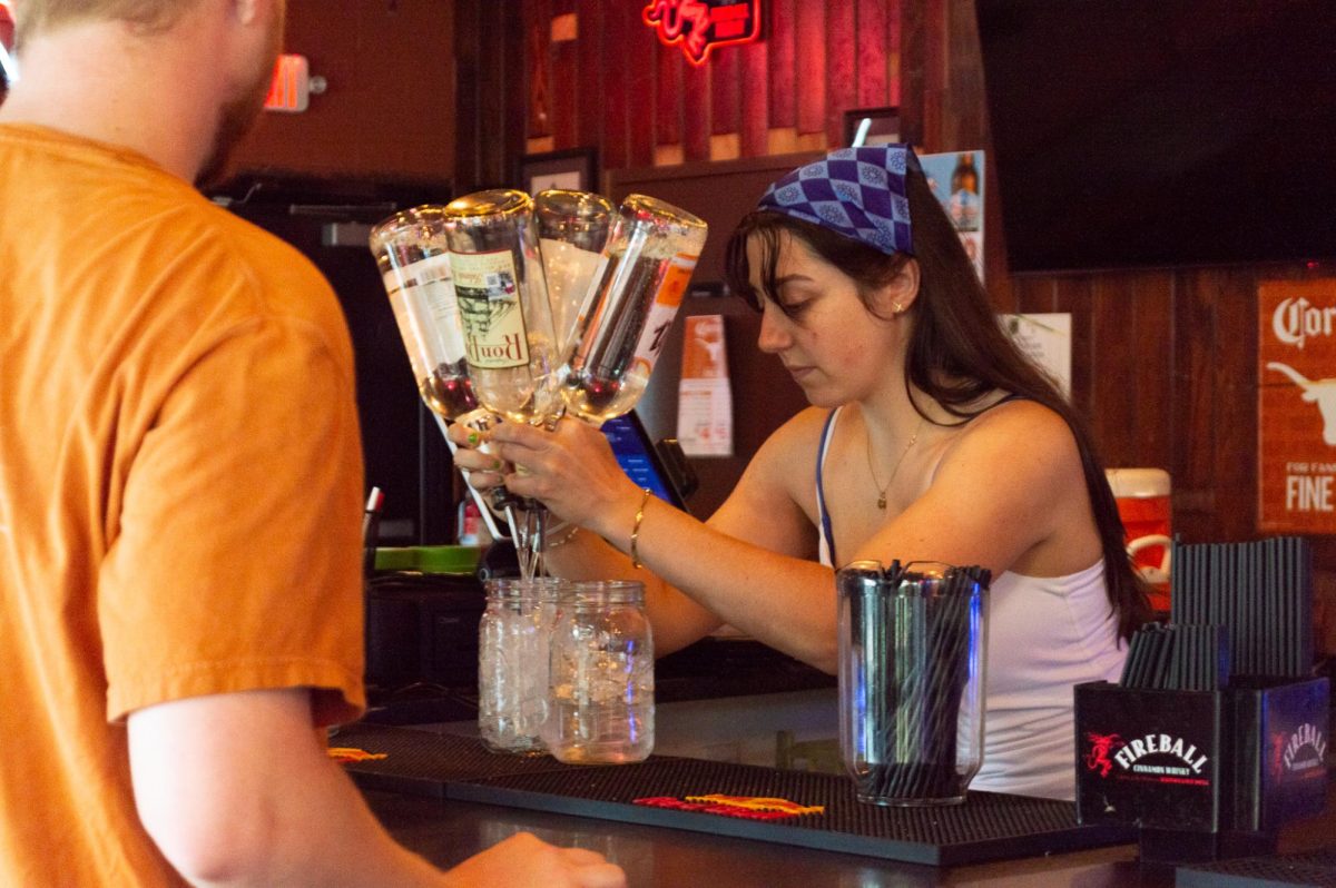Jules Dean, 2024 alumna and bartender at Cain and Abel’s in West Campus, prepares a drink on April 17, 2025.